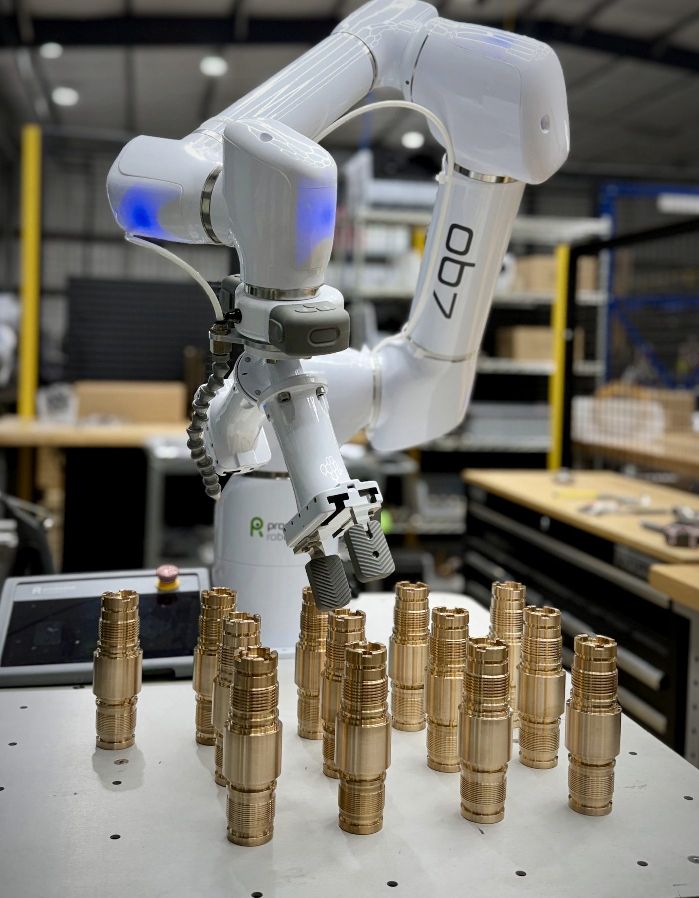 Collaborative robot staging machined copper-alloy parts on a fixture table