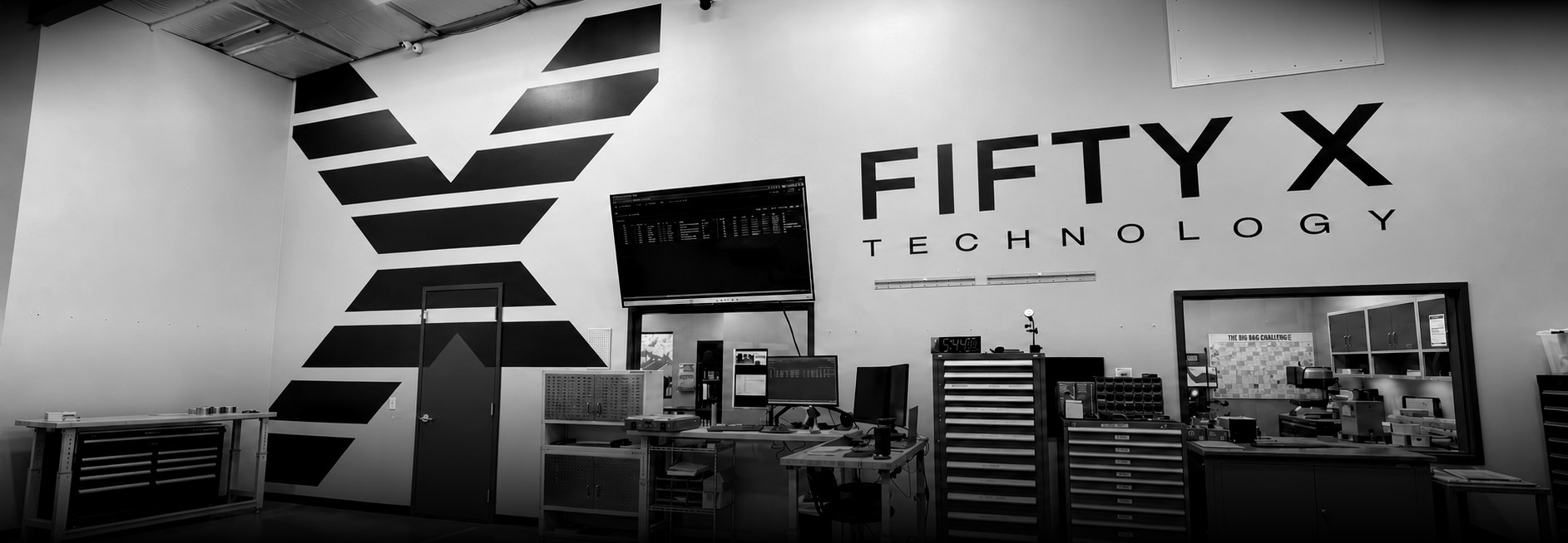 The Fifty X Technology mark and wordmark painted across the shop wall in Cypress, Texas